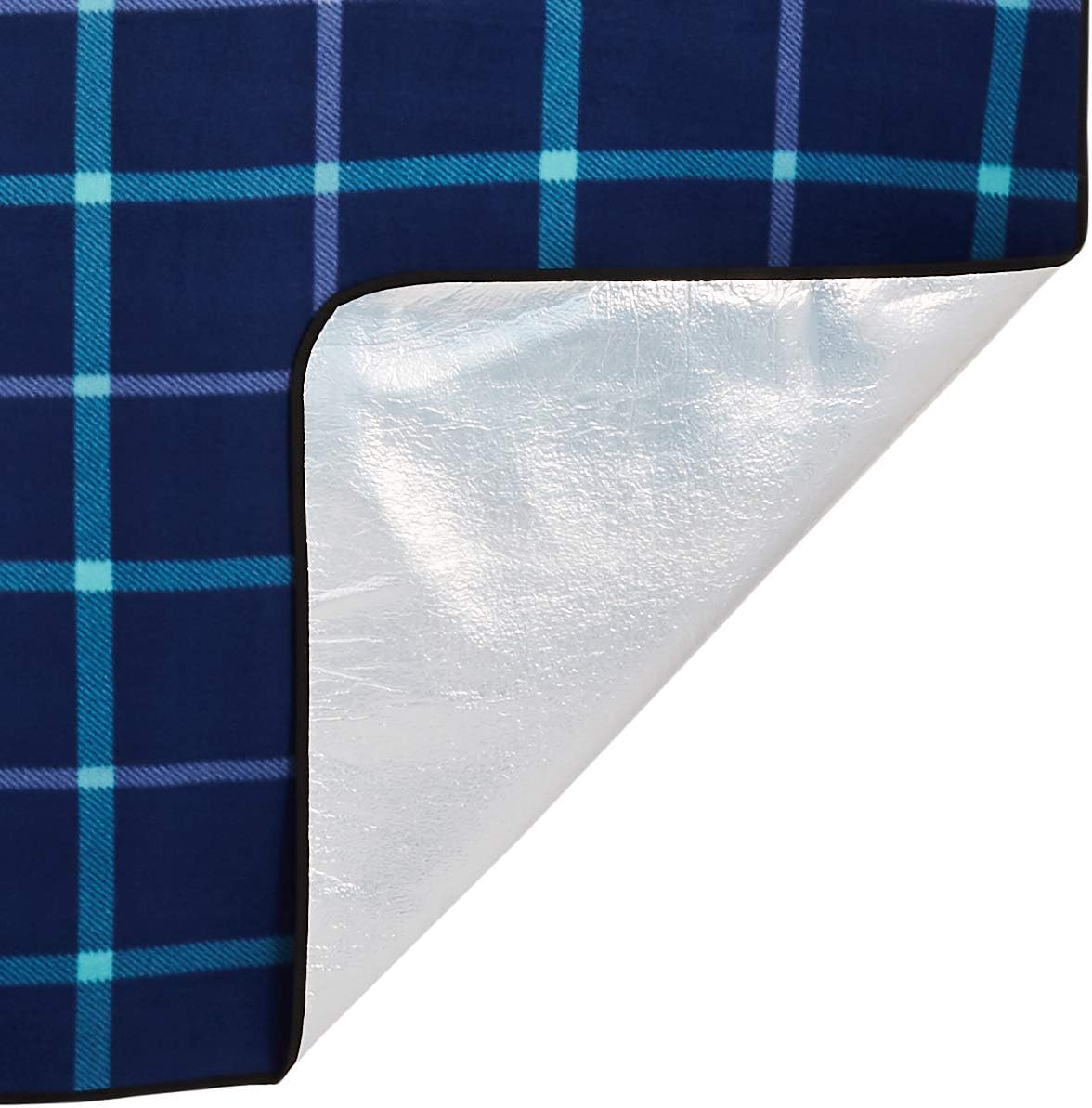 Corner of the Amazon Basics picnic blanket folded back to show the silver aluminium-coated waterproof backing
