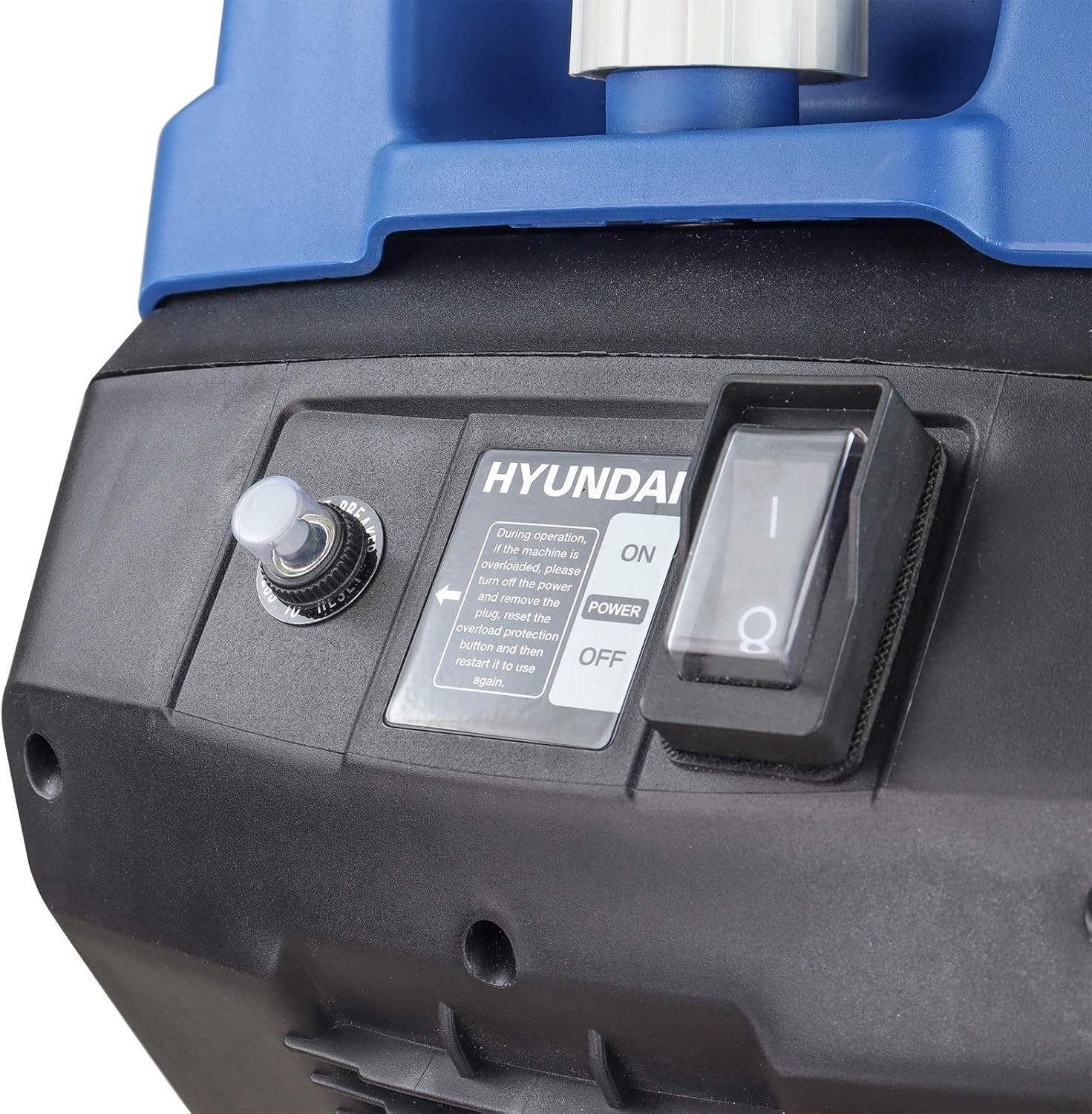 Close-up of the shredder control panel showing the overload reset button, the power rocker switch under a clear cover and the overload instruction plate