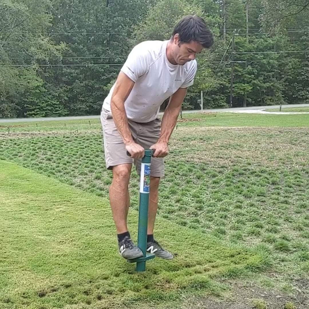 Gardener driving the ProPlugger into turf with both hands on the T-bar handle, on a lawn already worked over with cut plugs